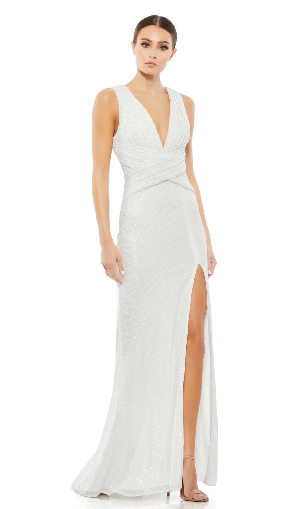 A woman models the Mac Duggal 26598, a sleeveless long formal dress with a deep V-neckline, wrap bodice, and thigh-high slit, paired with high-heeled sandals against a plain white background.